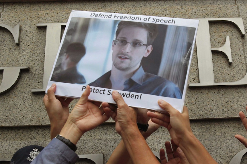 Supporters hold up a picture of Edward Snowden