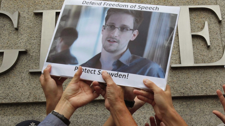 Supports hold up a picture of Edward Snowden