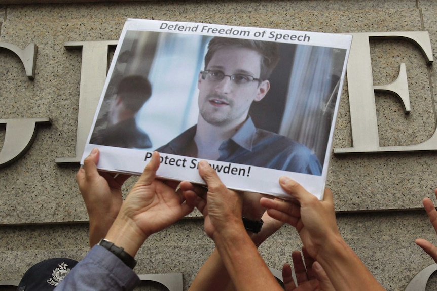 Supports hold up a picture of Edward Snowden