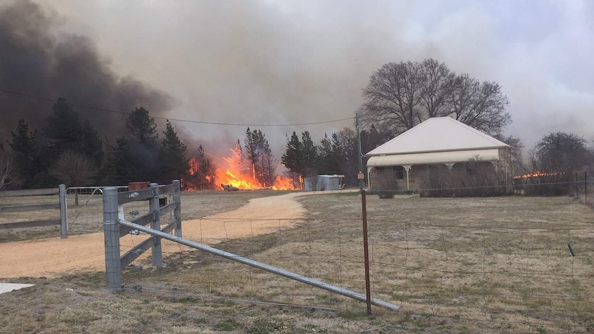 A bushfire burns close to a home