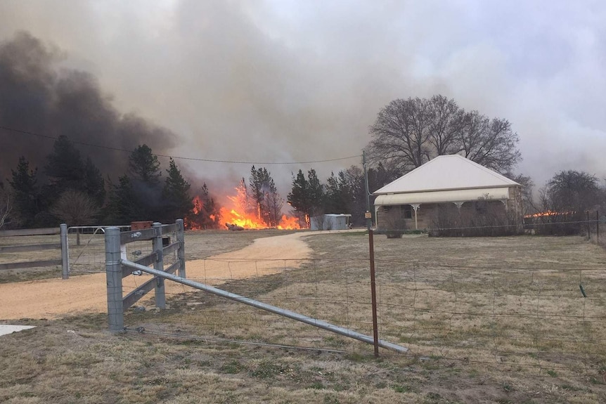 A bushfire burns close to a home