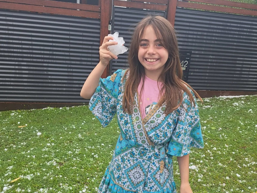 A little girl holding up some hail