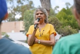 A woman speaks into a mic