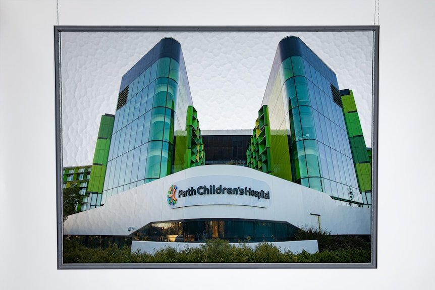 A photo of the exterior of Perth Children's Hospital. The building has been placed in a frame of tempered glass. 