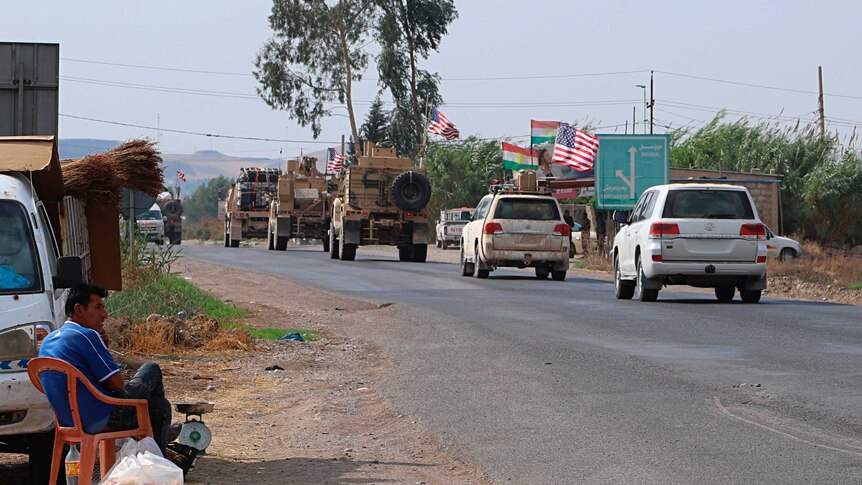 A US military convoy, consisting of armoured vehicles and four-wheel drives with US flags, arrives near Dahuk, Iraq.