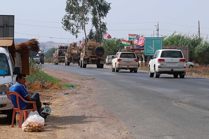 A US military convoy, consisting of armoured vehicles and four-wheel drives with US flags, arrives near Dahuk, Iraq.