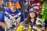 Man and woman stand in an nrl apparel store in Bulldogs and Cowboys merchandise