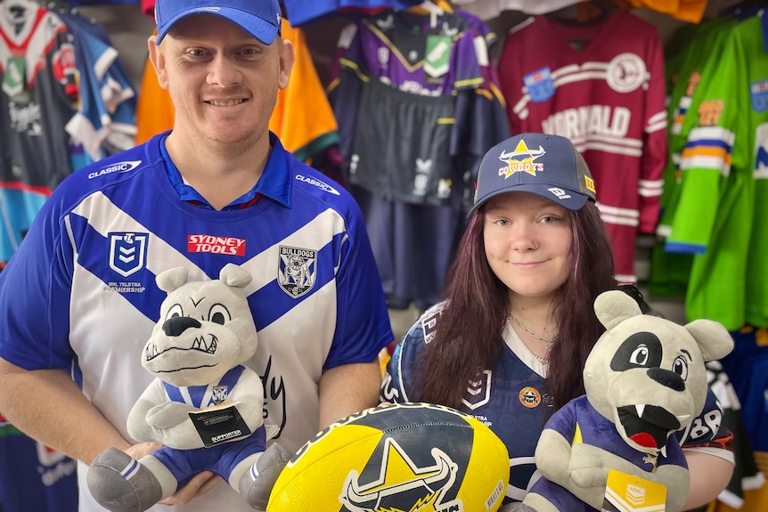 Man and woman stand in an nrl apparel store in Bulldogs and Cowboys merchandise