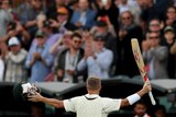 Seen from behind, Australia batsman David Warner raises his bat and helmet to the crowd.