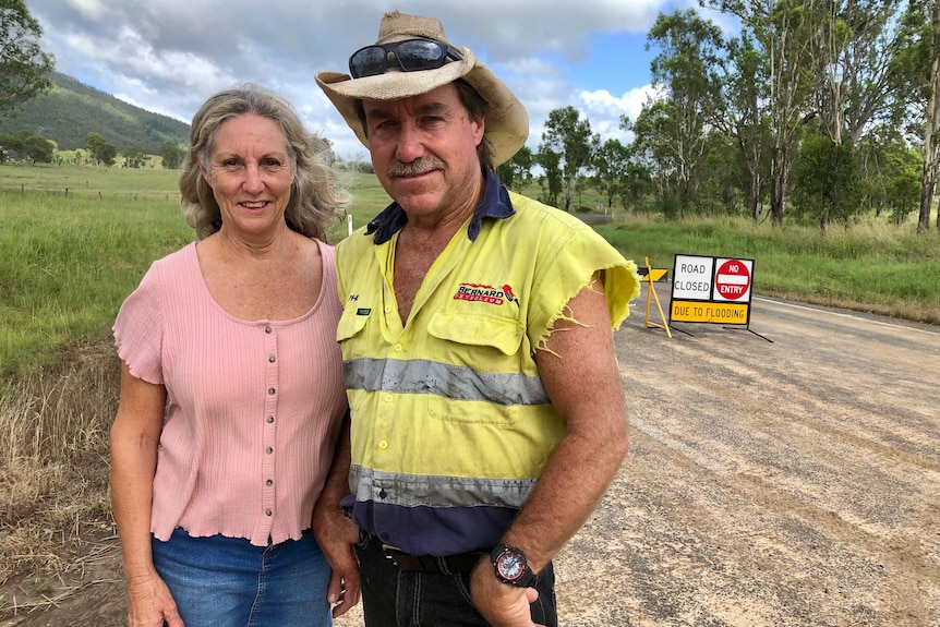 A man and woman standing together on a dirt road