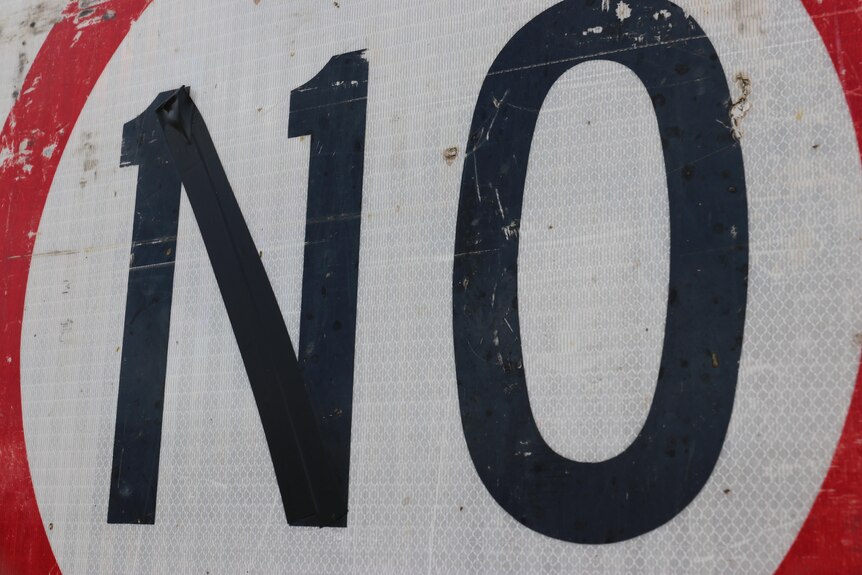 A road sign that has been defaced so that it reads "No".