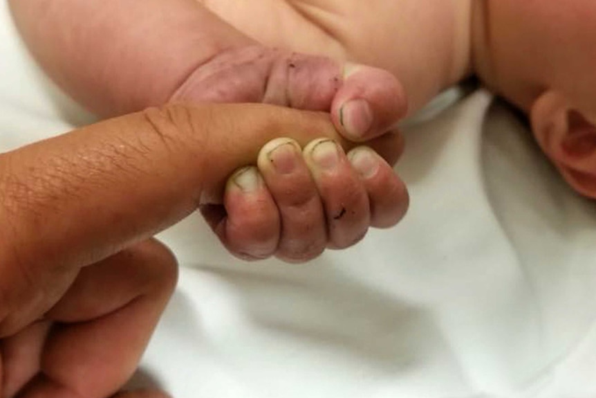 The hand of 5-month-old infant with dirt under their fingernails