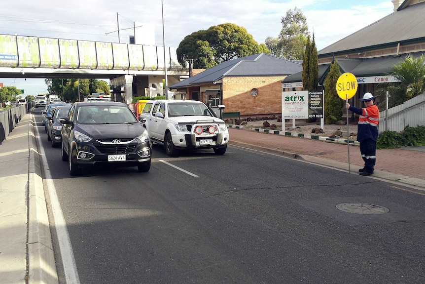 Transport Department staff stop traffic on South Road.