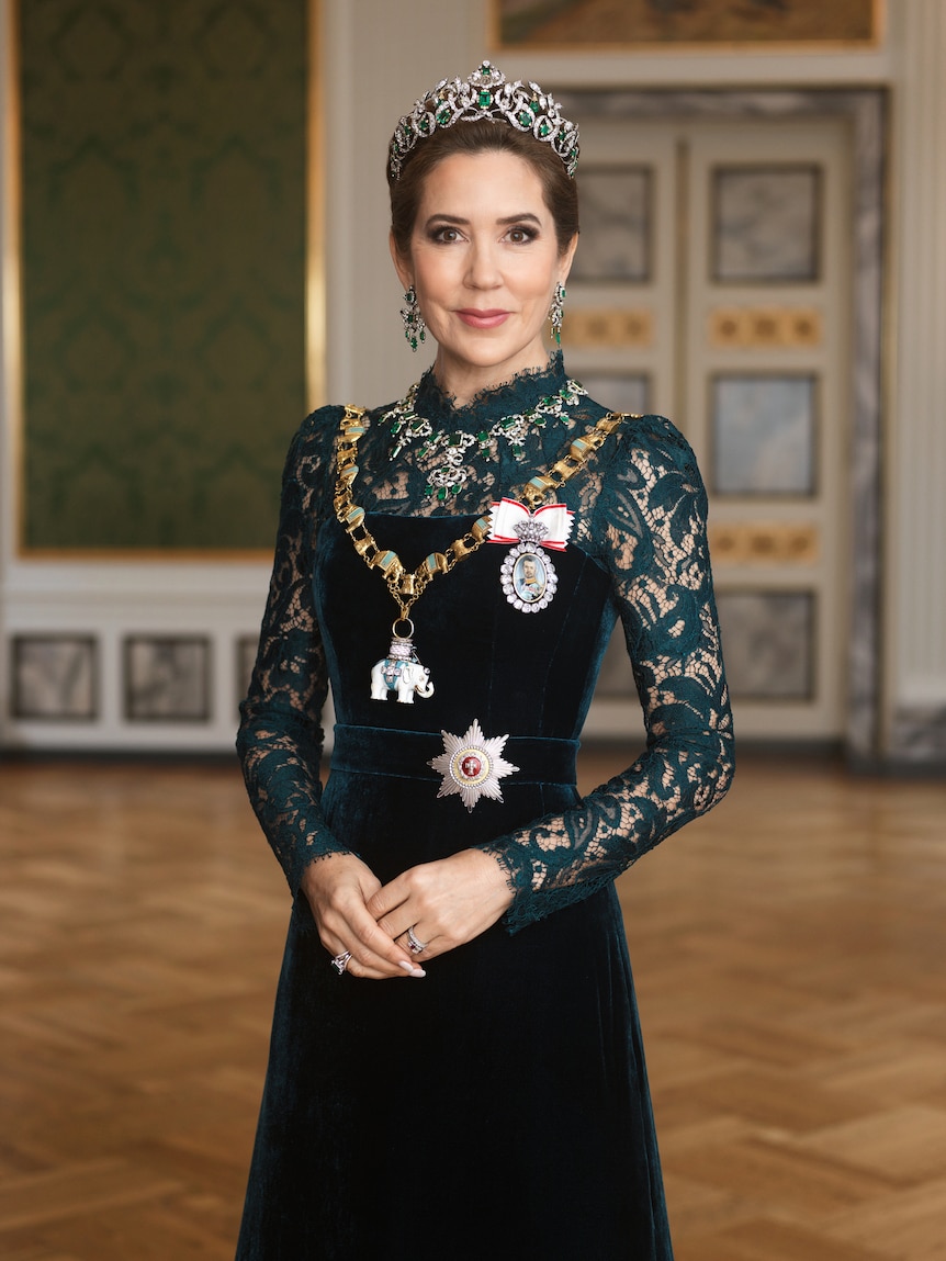 A portrait of Queen Mary of Denmark wearing a long dress with lace details on the sleevesand a crown.