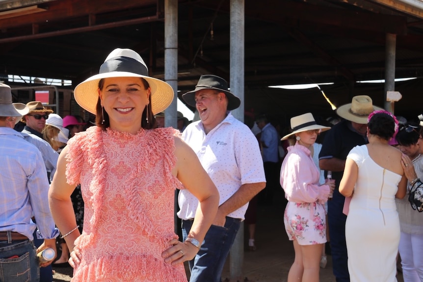 Woman in pink dress and white hat at horse races