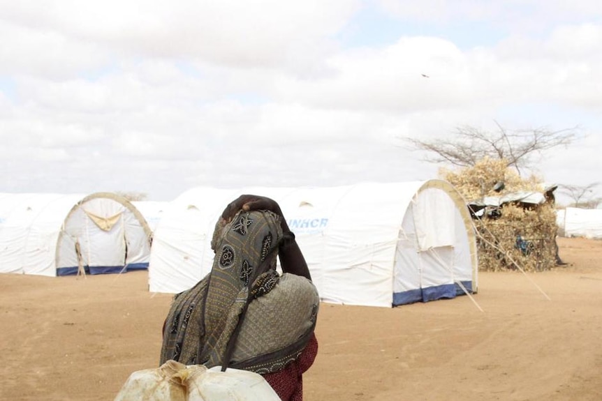 A Somali refugee carries water in camp near the Kenya-Somalia border, April 3, 2011.