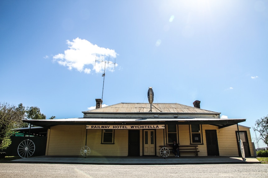 Exterior photo of a one-storey building with sloping corrugated iron roof and broad verandah