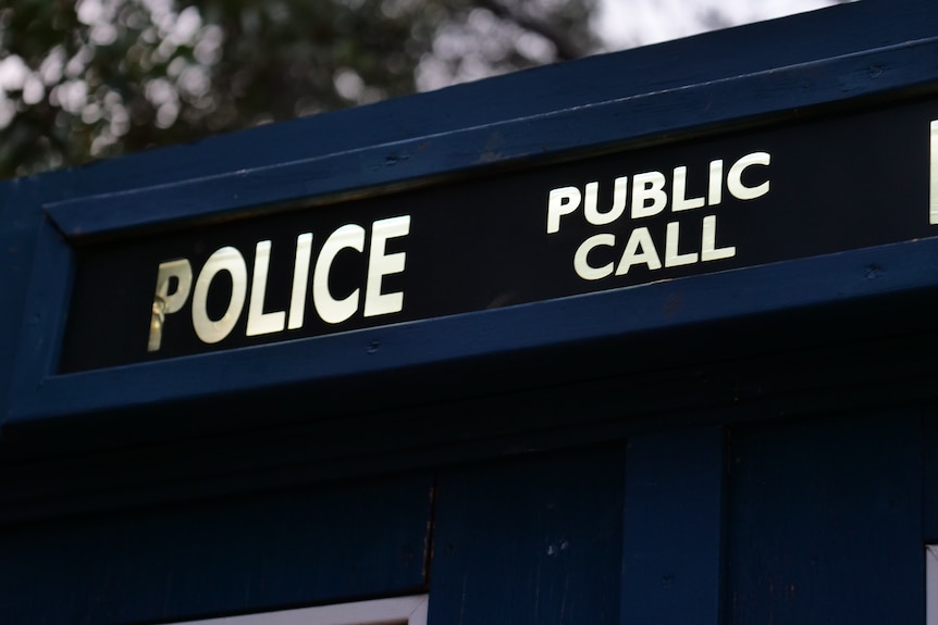 The top sign of a police box, with the words police and public call illuminated.