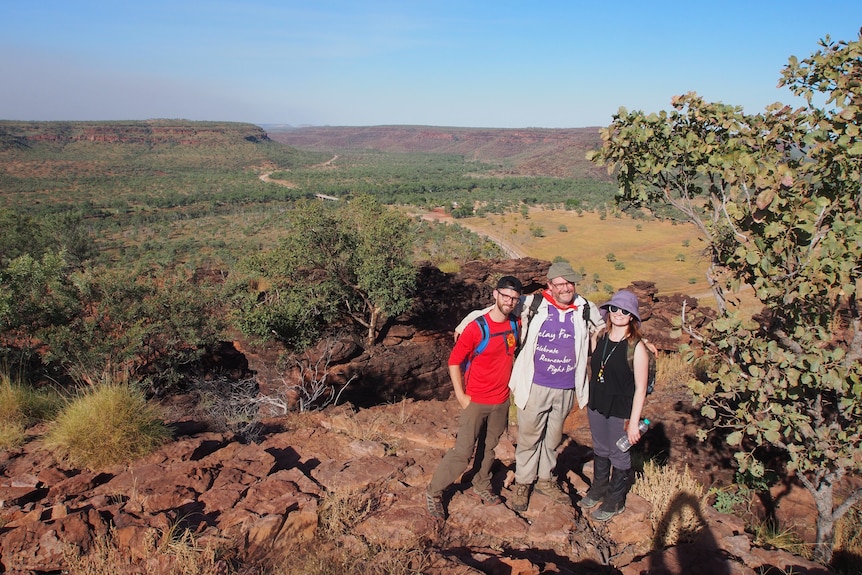 Three researchers stand on at a lookout point in a national park in NT.
