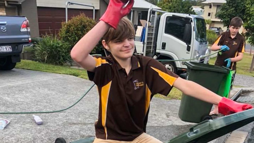 Young boy sitting on a bin.