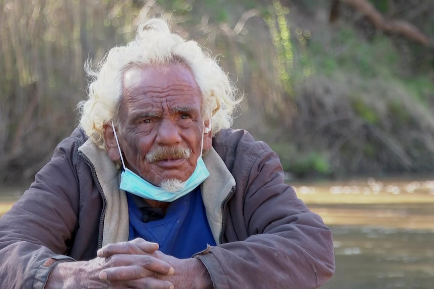 A man wears a mask under his chin.