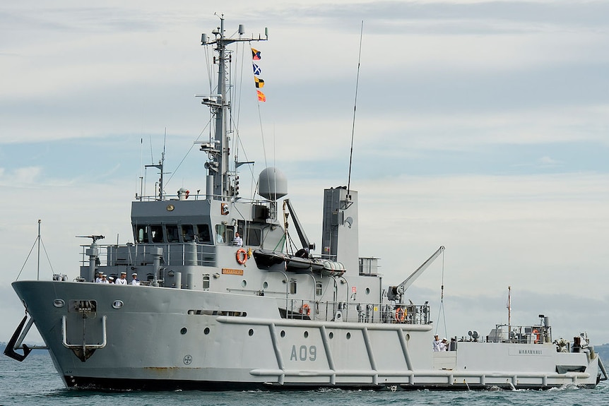 A grey warships sails on the ocean