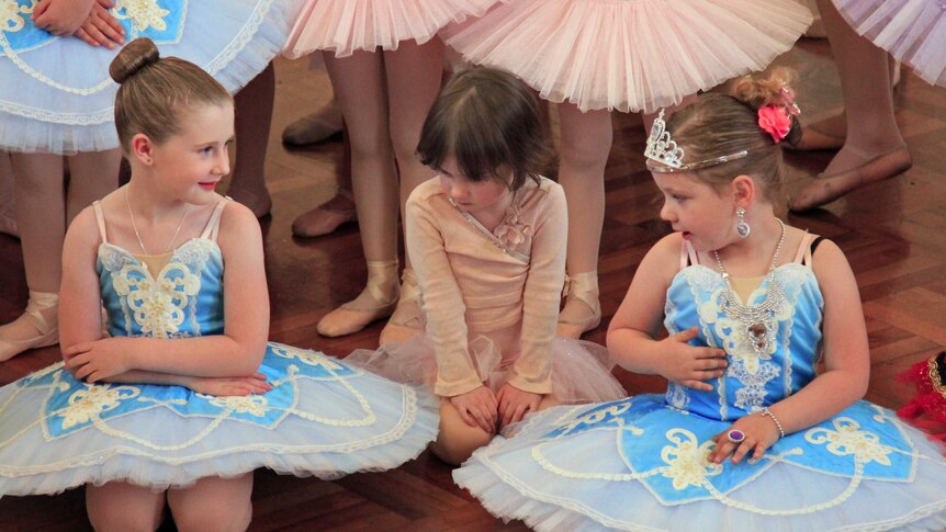 Young girls in ballet dress sitting on the floor
