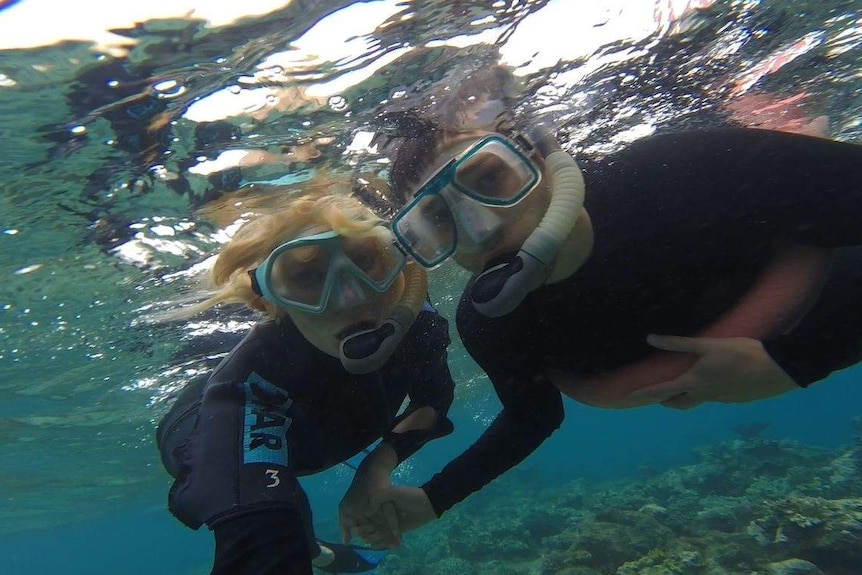 A man and woman snorkelling in the water