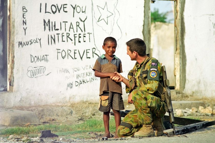 An INTERFET Australian soldier talking to a boy in East Timor, file photo