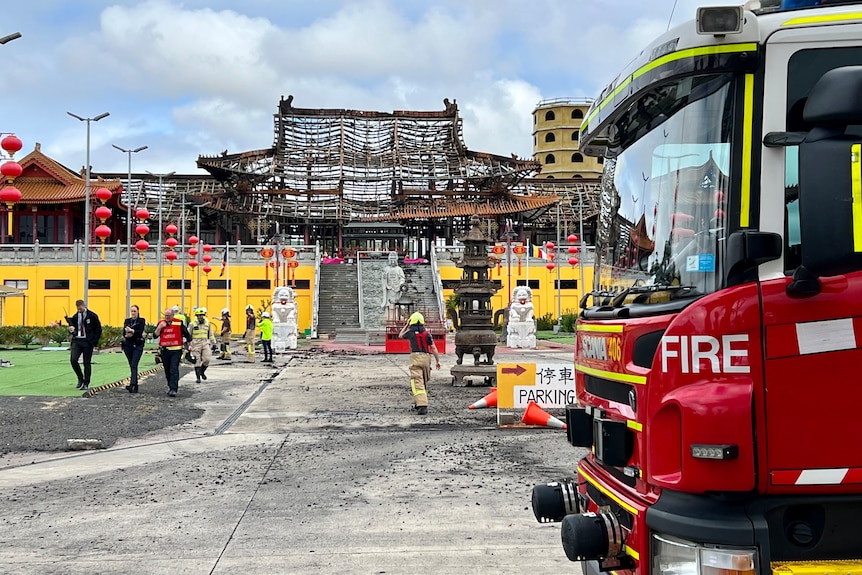 A badly damaged temple and a fire truck parked out the front.