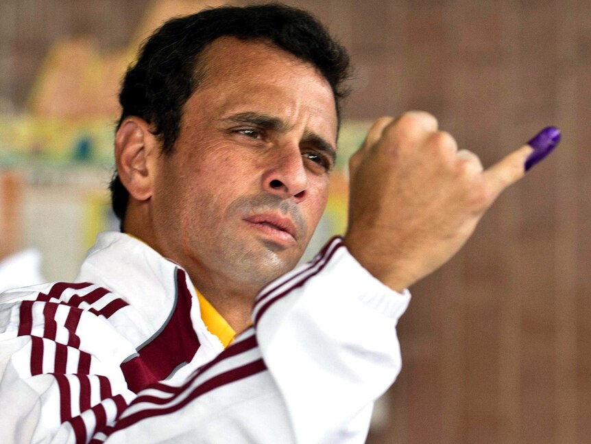 Henrique Capriles shows his stained finger after voting.