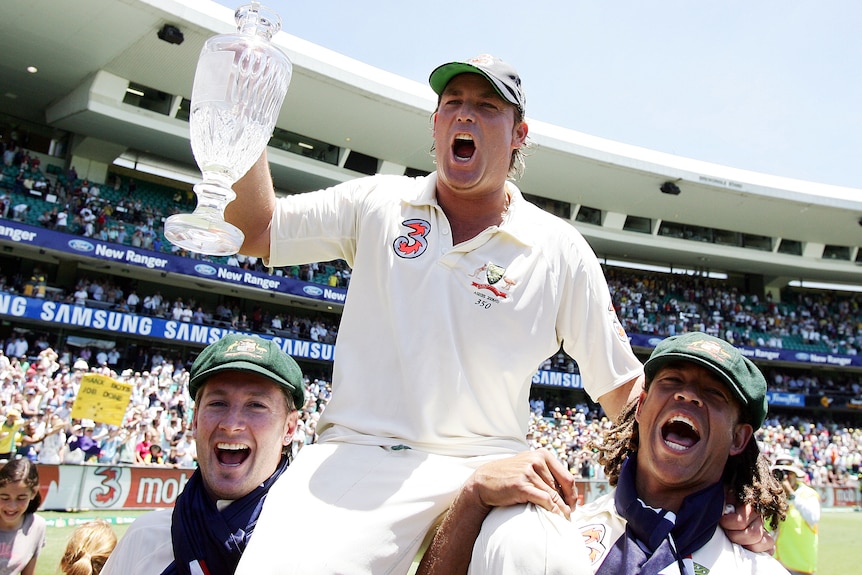 Shane Warne cheers as he is carried on the shoulders of Michael Clarke and Andrew Symonds.