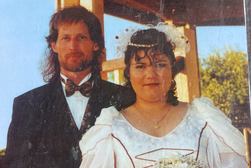 a photo of an old printed-out wedding portrait showing a bride and groom smiling for the camera