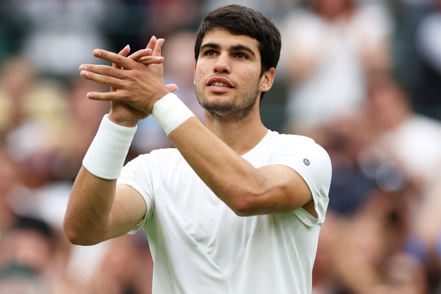 Carlos Alcaraz claps to the crowd after a first round win at Wimbledon.