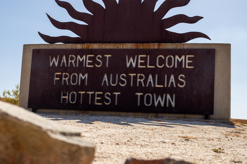 metal sign saying 'warmest welcome from Australia's hottest town'