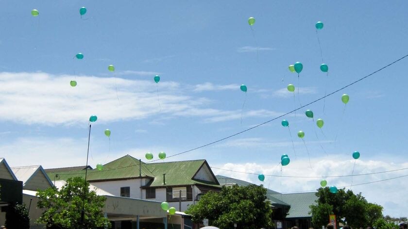 The honour guard outside St Patrick's College release balloons into the sky.