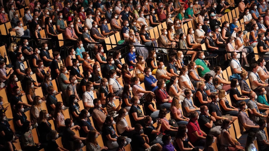 People attend a socially distanced concert in Germany, seated and wearing masks