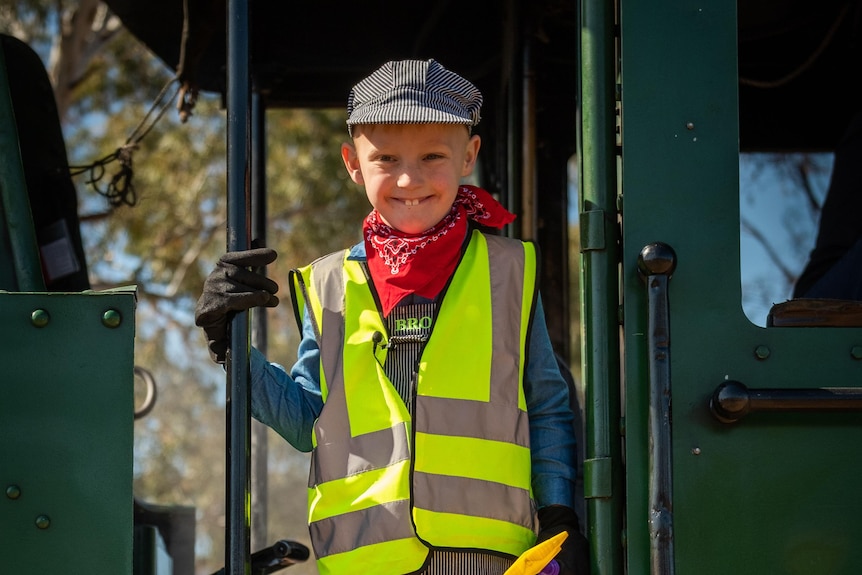 Broly aged 7 wearing a bright yellow vest standing on the outside of the Pichi Richi steam train 