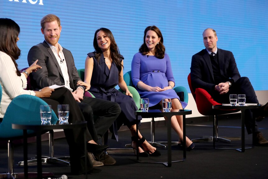 Prince Harry, Meghan Markle, Catherine and Prince William sitting and smiling during an interview.
