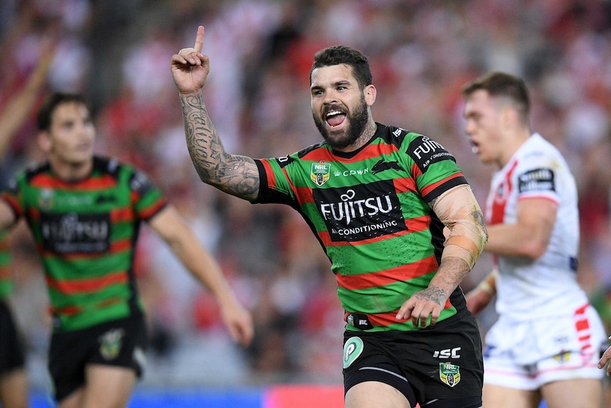 Adam Reynolds celebrates by raising his finger after kicking a winning field goal for the Rabbitohs.