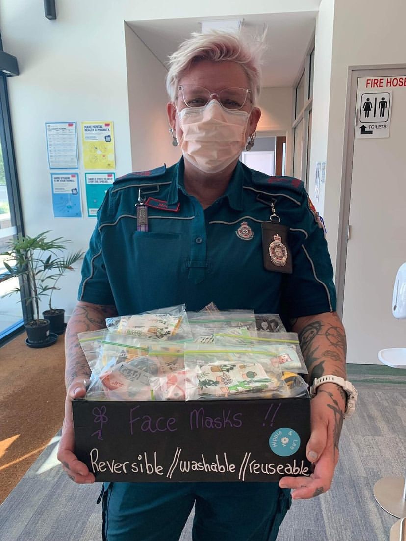 an ambulance officer holds a box on face masks