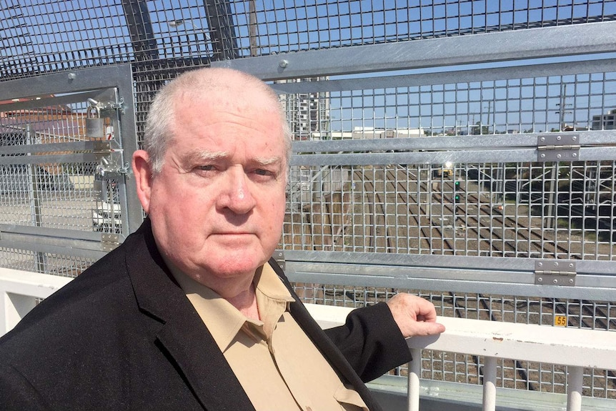 Barry Gobbe standing on the pedestrian bridge over the railway tracks.