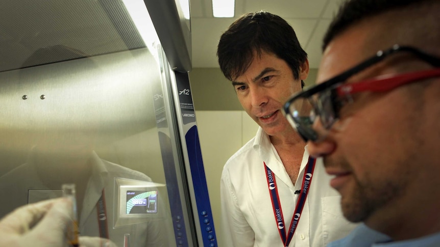 Dr Lloyd Einsiedel and researcher Joel Liddle analyse a vial of blood