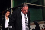 Tasmanian DPP Tim Ellis walks into Hobart Magistrates Court followed by his wife Anita Smith.