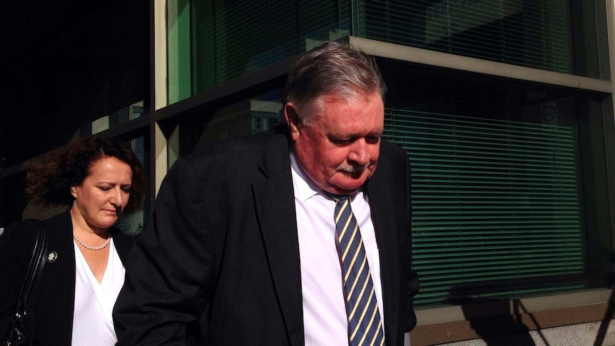 Tasmanian DPP Tim Ellis walks into Hobart Magistrates Court followed by his wife Anita Smith.