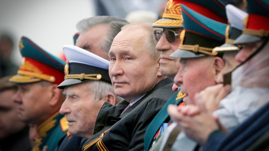 Vladimir Putin surrounded by Russian military generals in uniform 