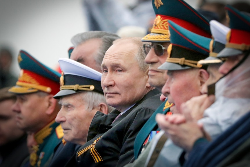 Vladimir Putin surrounded by Russian military generals in uniform 