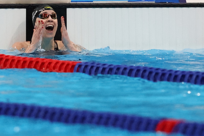 Swimmer Sophie Pascoe raises her hands to the face and looks ecstatic after she looks to the scoreboard after wining a race.