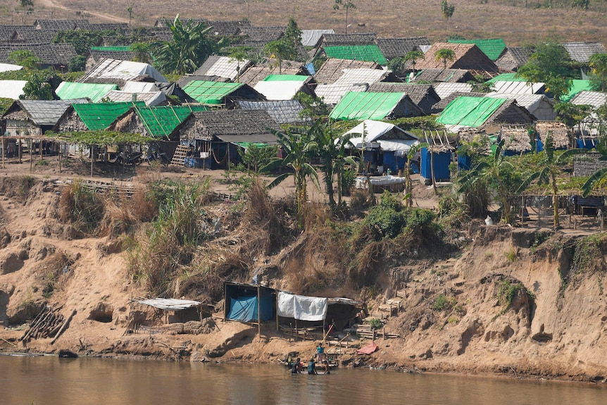 Improvised shelters on the bank of a river.