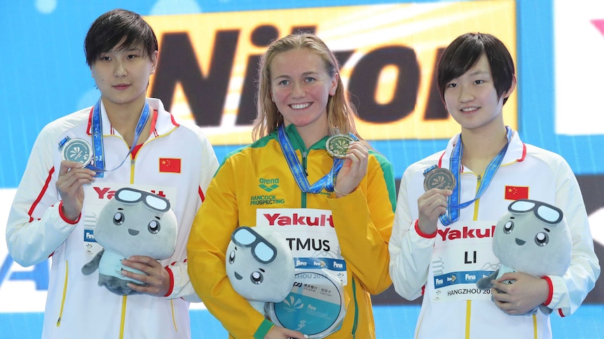 Ariarne Titmus (C) on the podium after winning the 400m freestyle at the world short course titles.